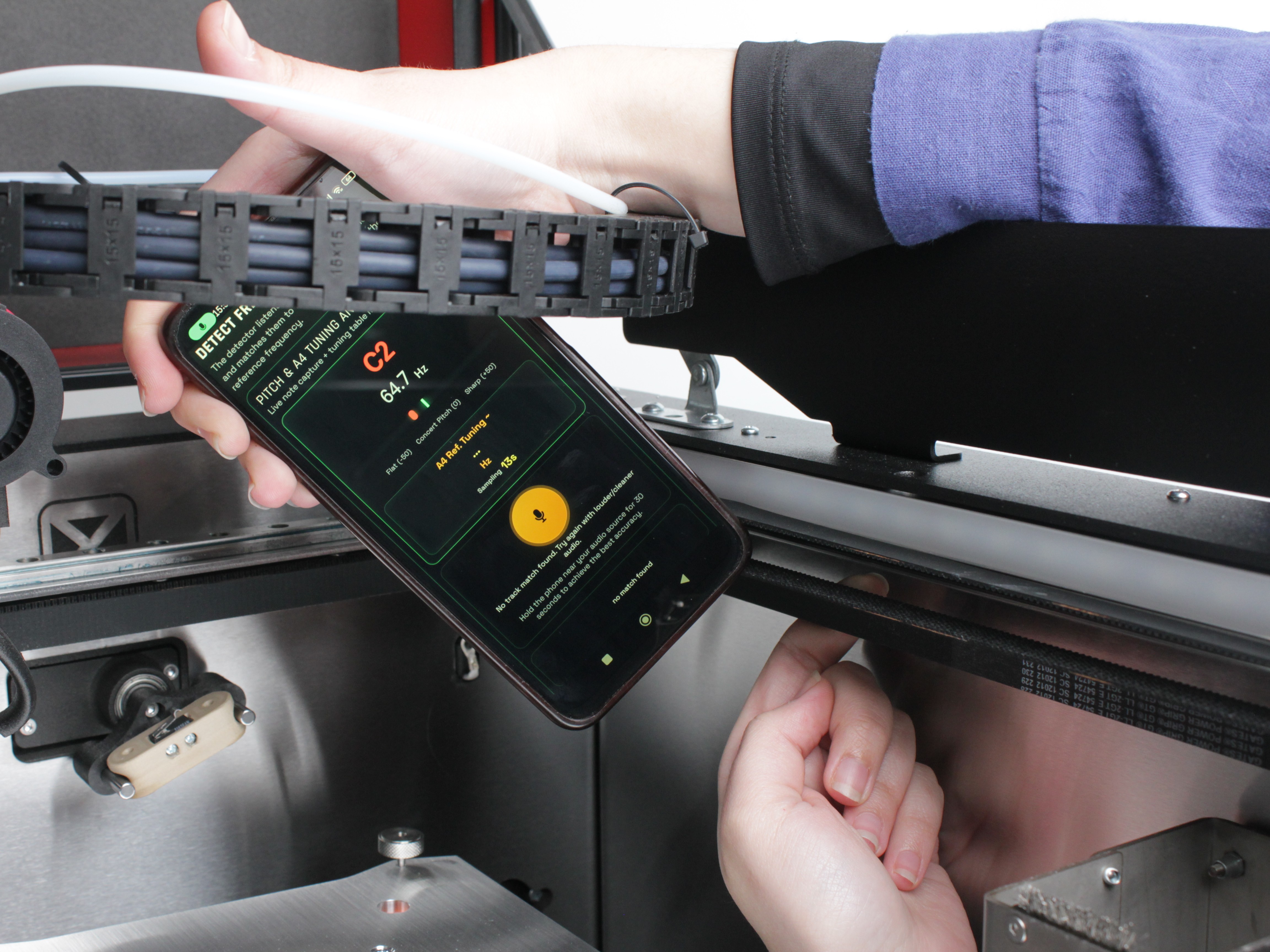 Phone with tuning app next to the tool belt being plucked