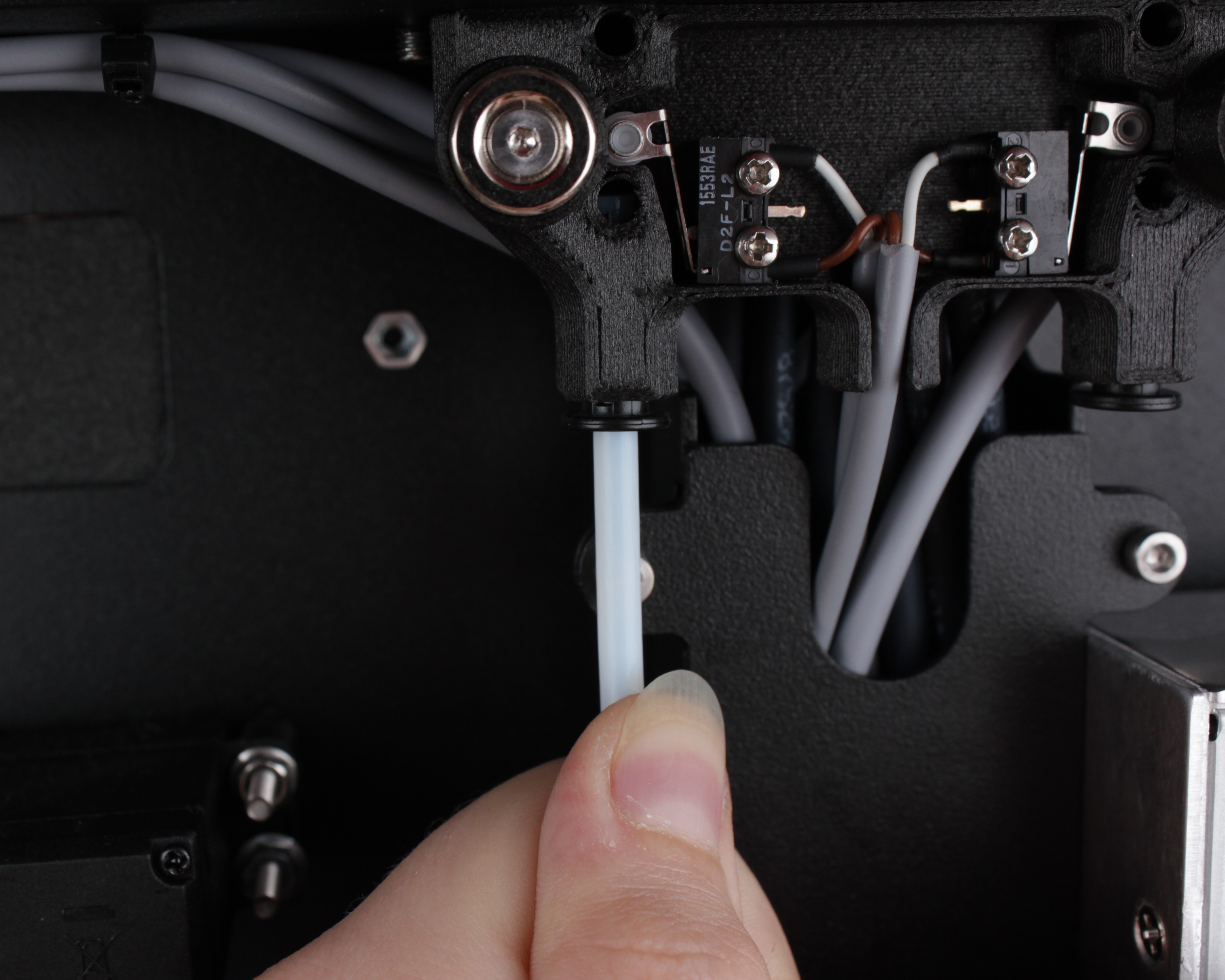Tugging the PTFE tube after inserting it into the sensor mount connector to verify it holds.