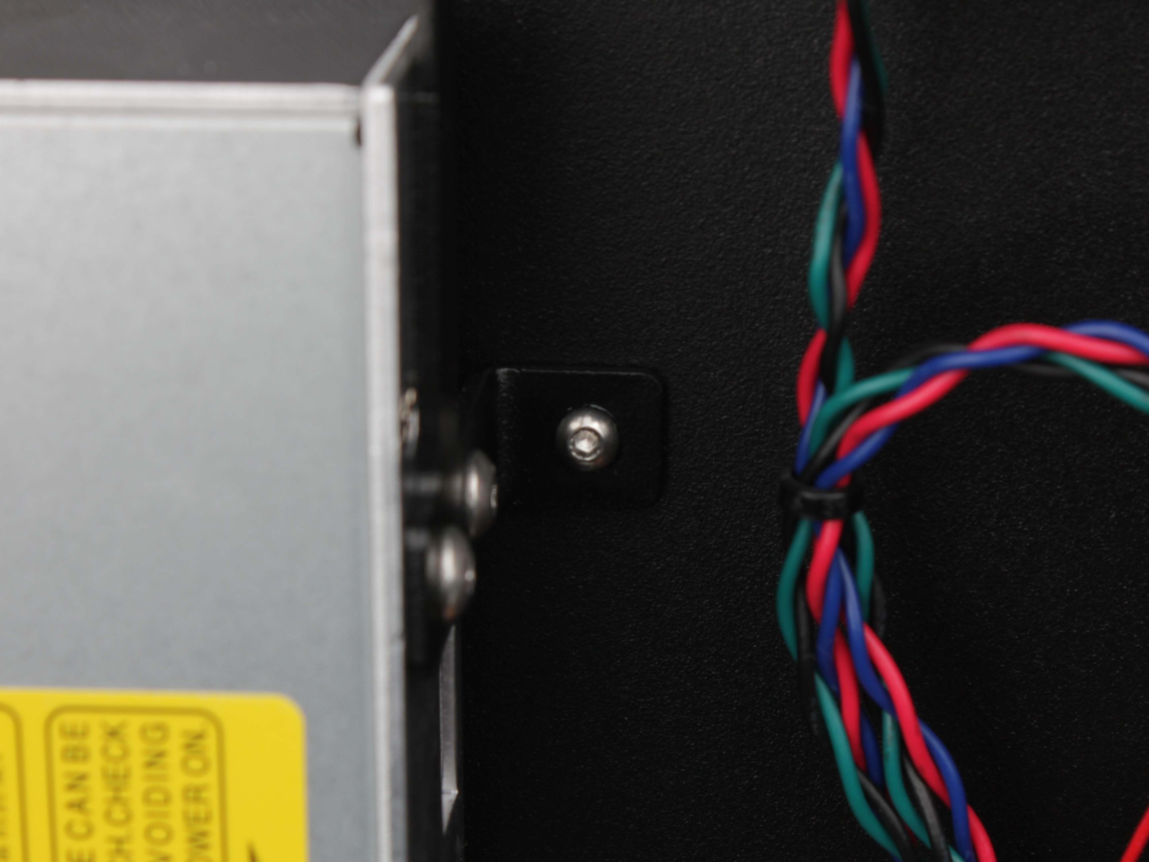 L-shaped bracket secured to chassis on the right side of new PSU