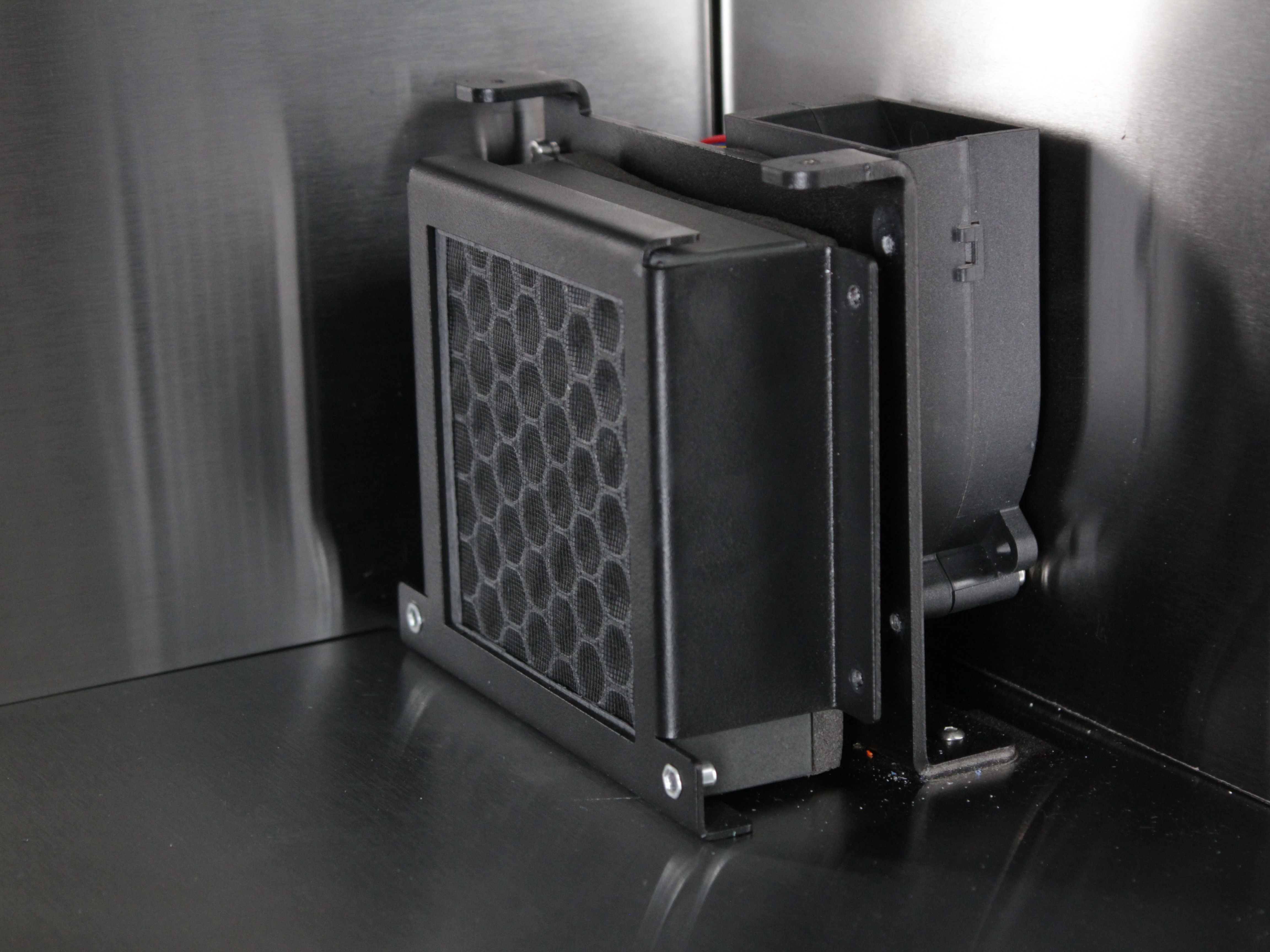 HEPA filter bracket positioned with rear tabs hooked onto mounting points.