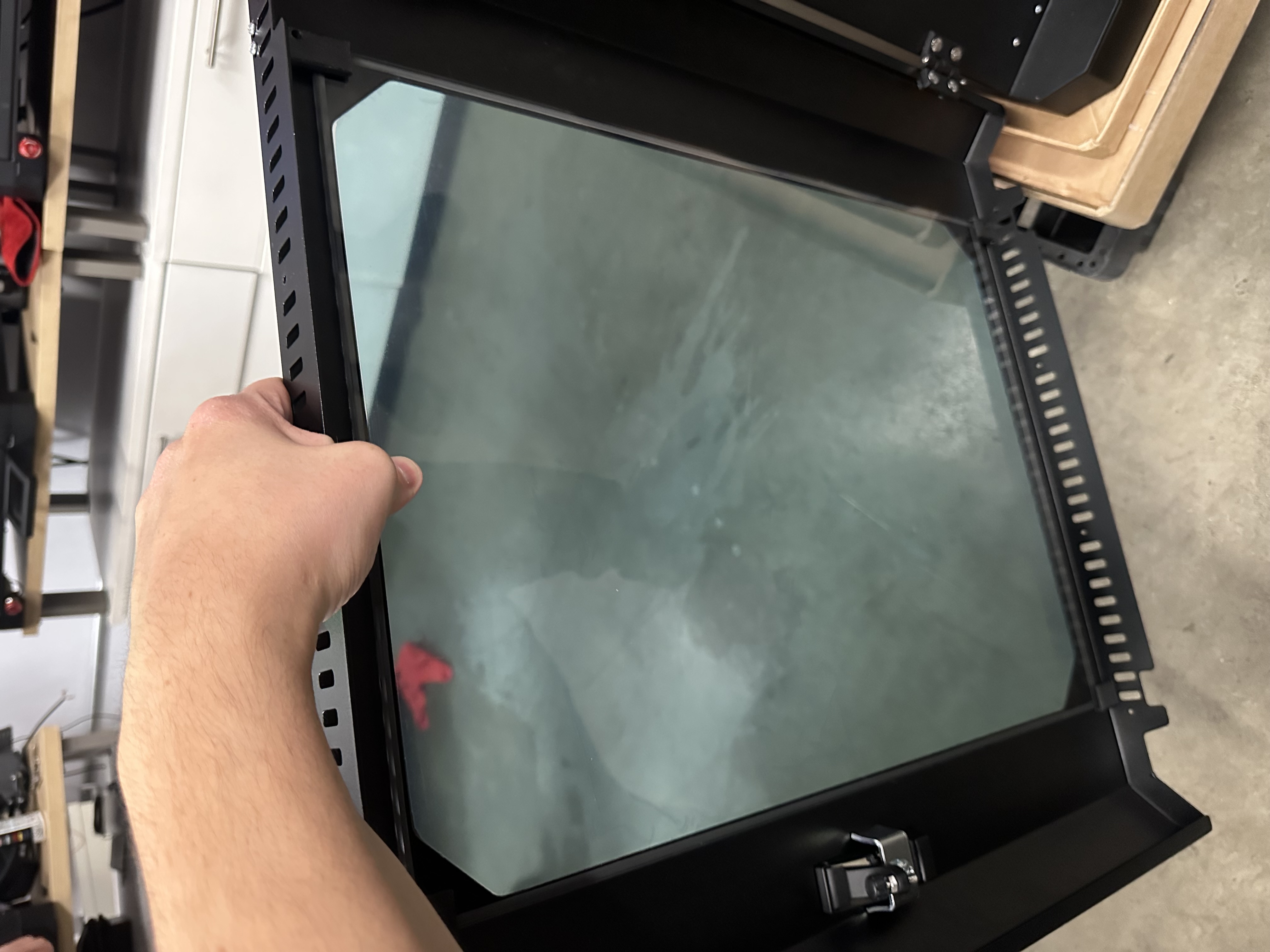 Hand holding the glass centered in the frame while the brackets are loose