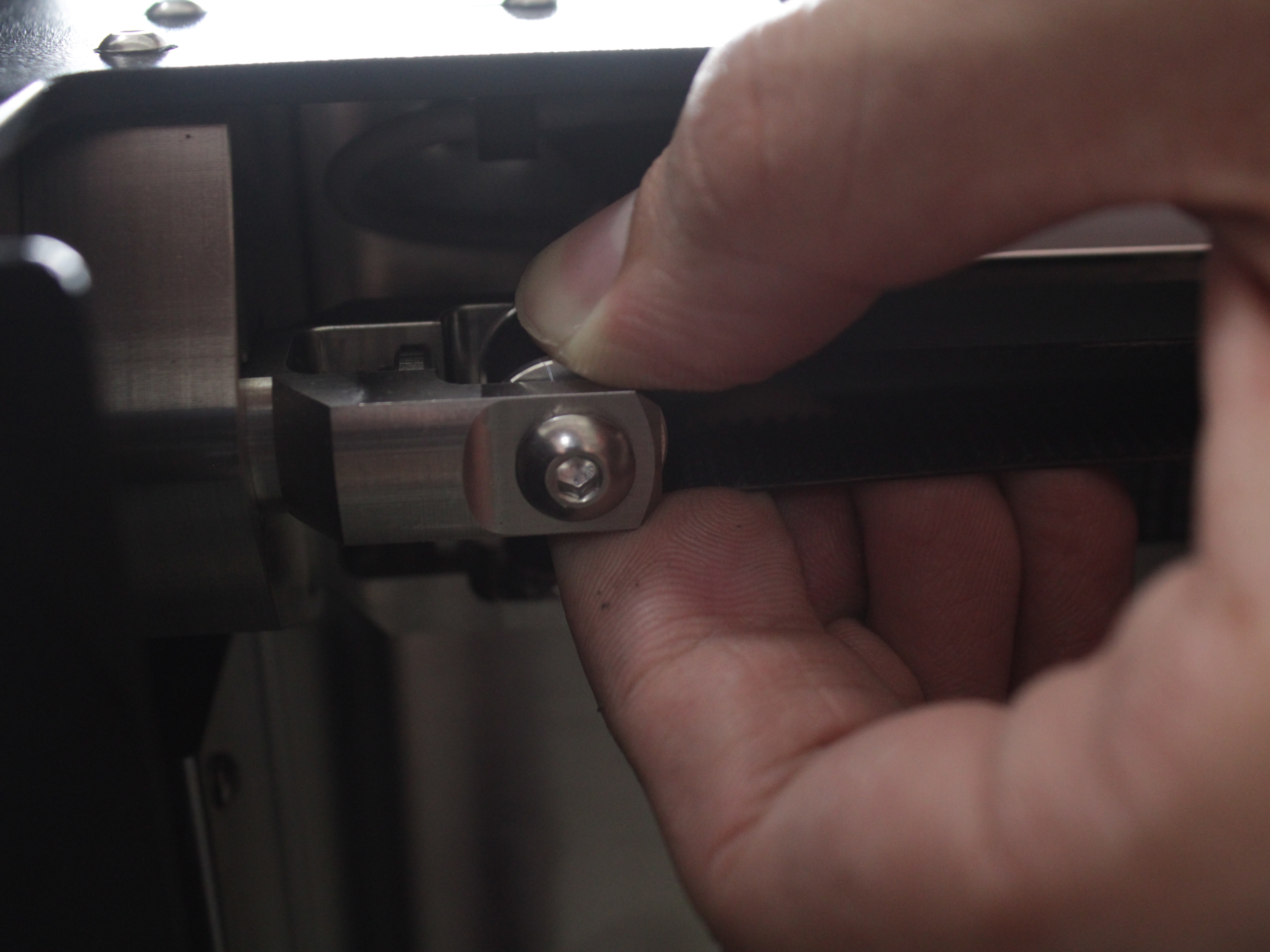 Spinning a front idler roller by hand to check the bearing