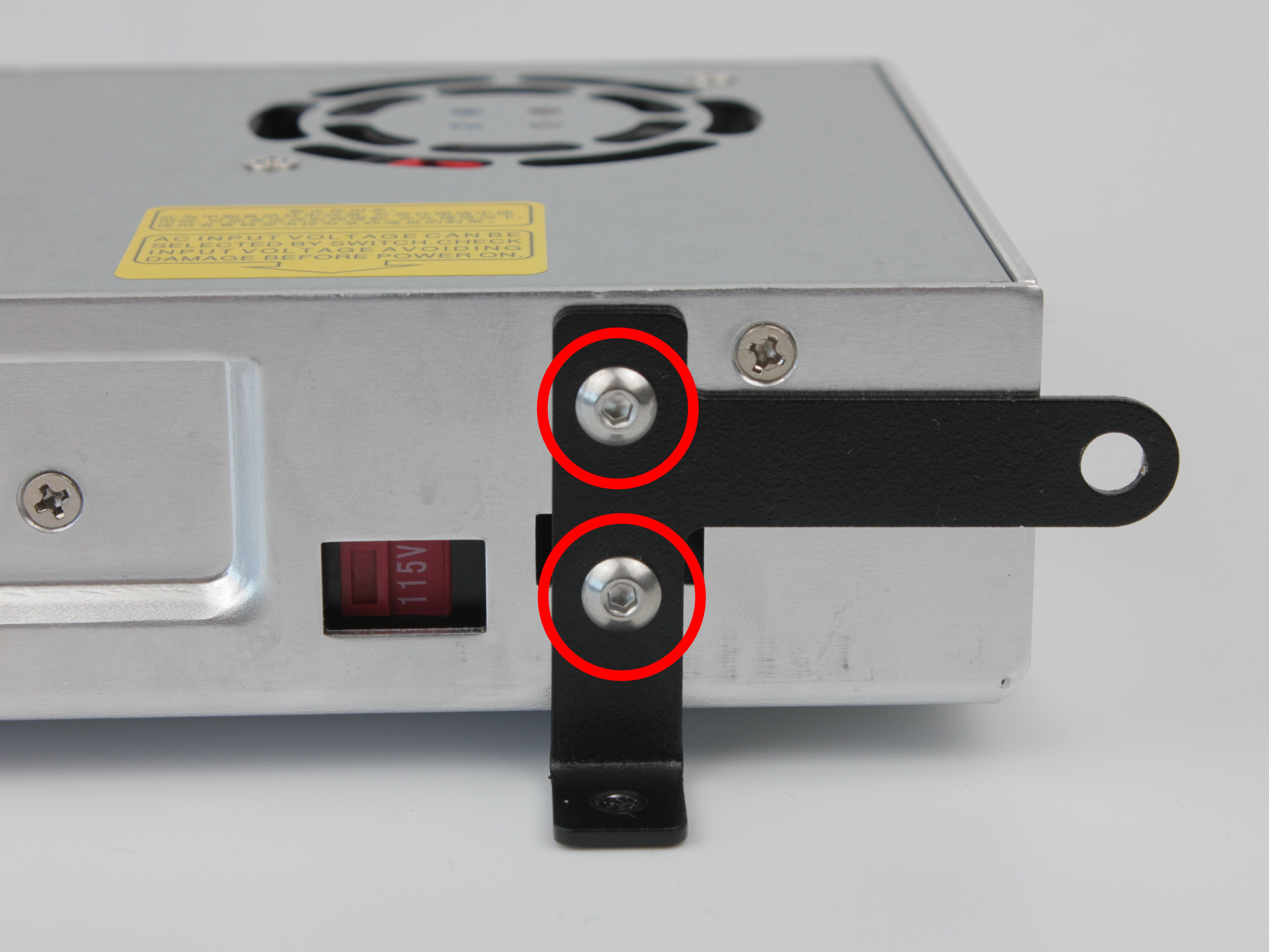 L-shaped bracket being unscrewed from the old PSU
