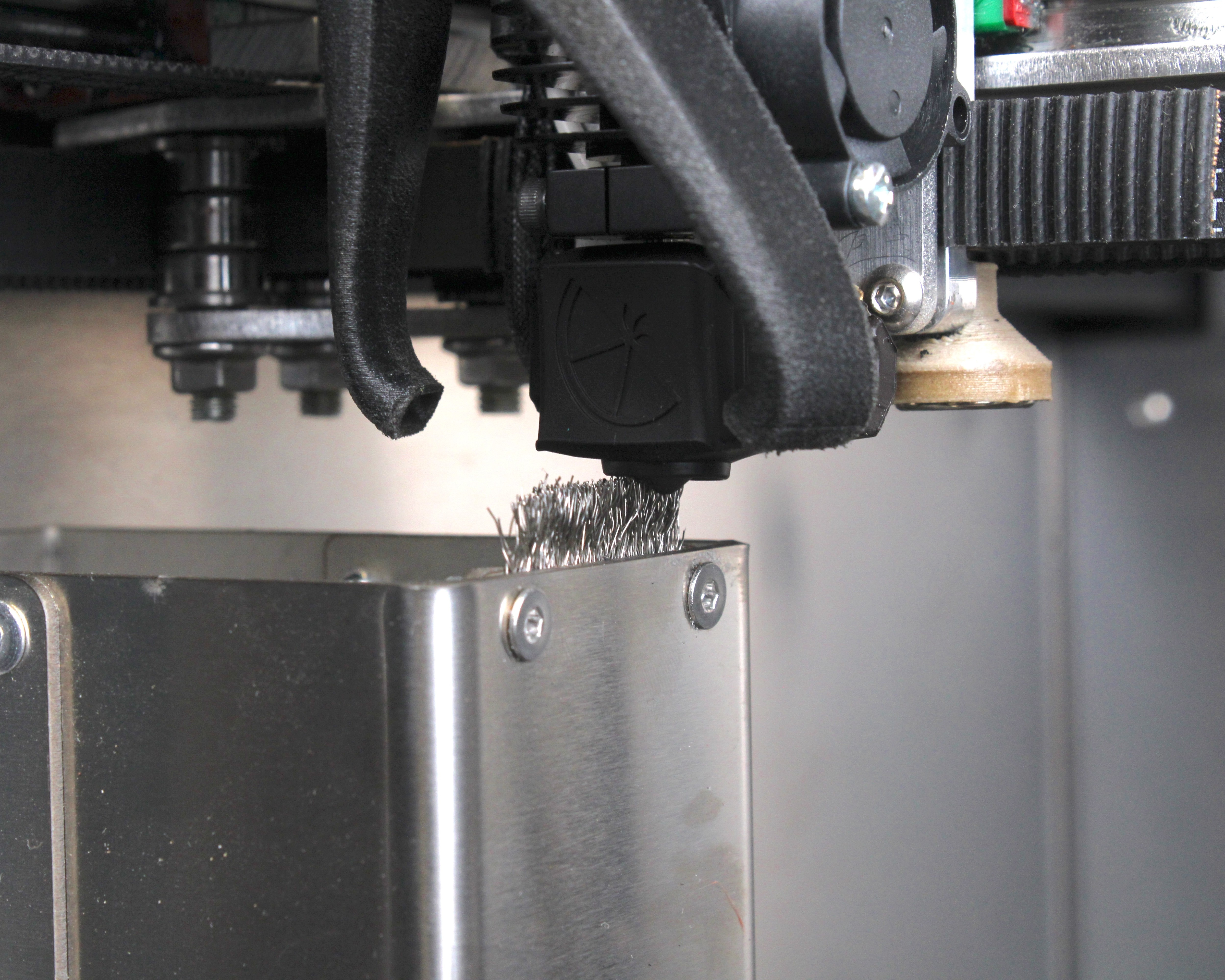 Brush raised so bristle tips sit about 2–3 mm above the nozzle tip