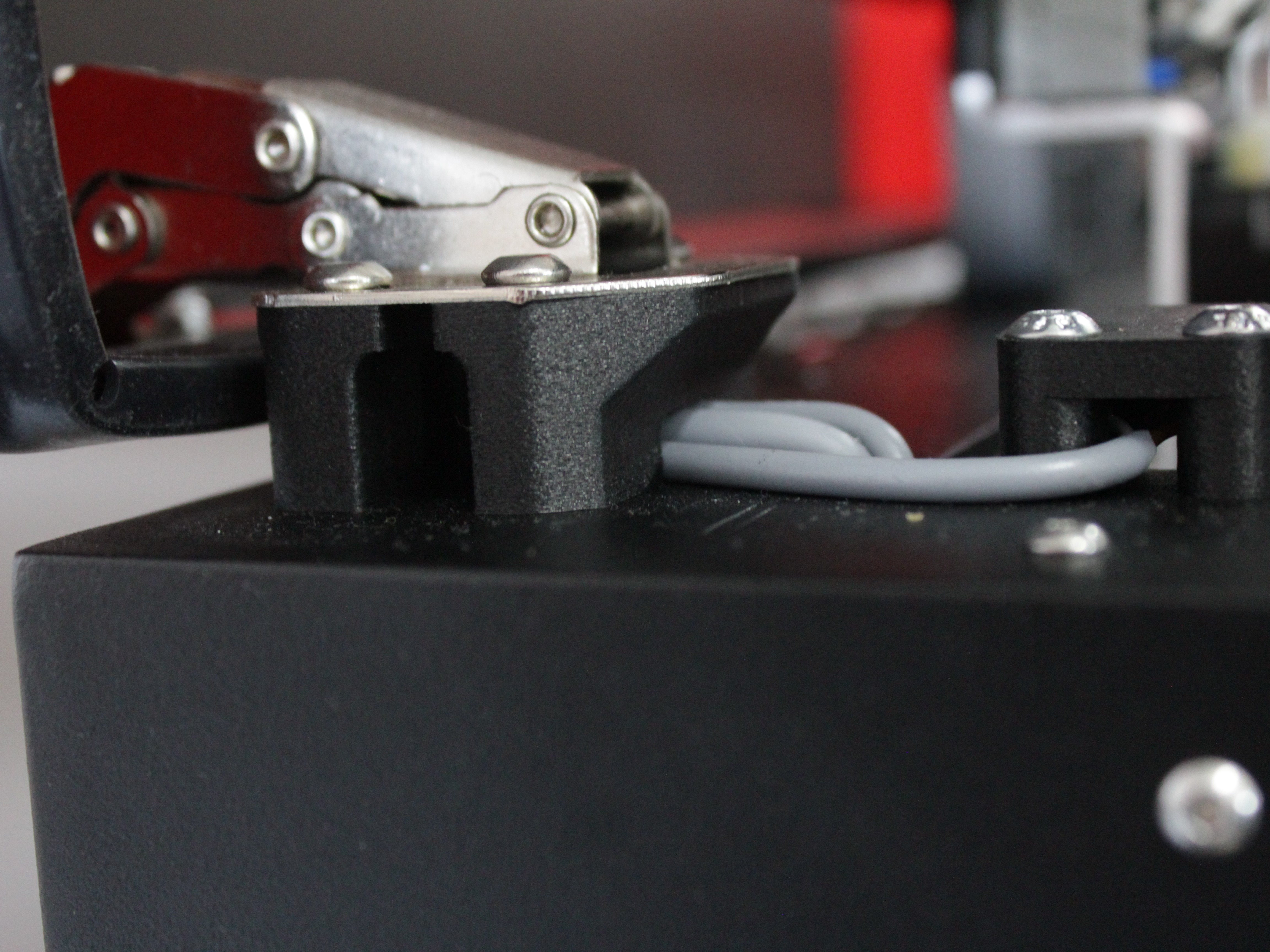 Inspecting endstop wire path at lid hinge spacers.