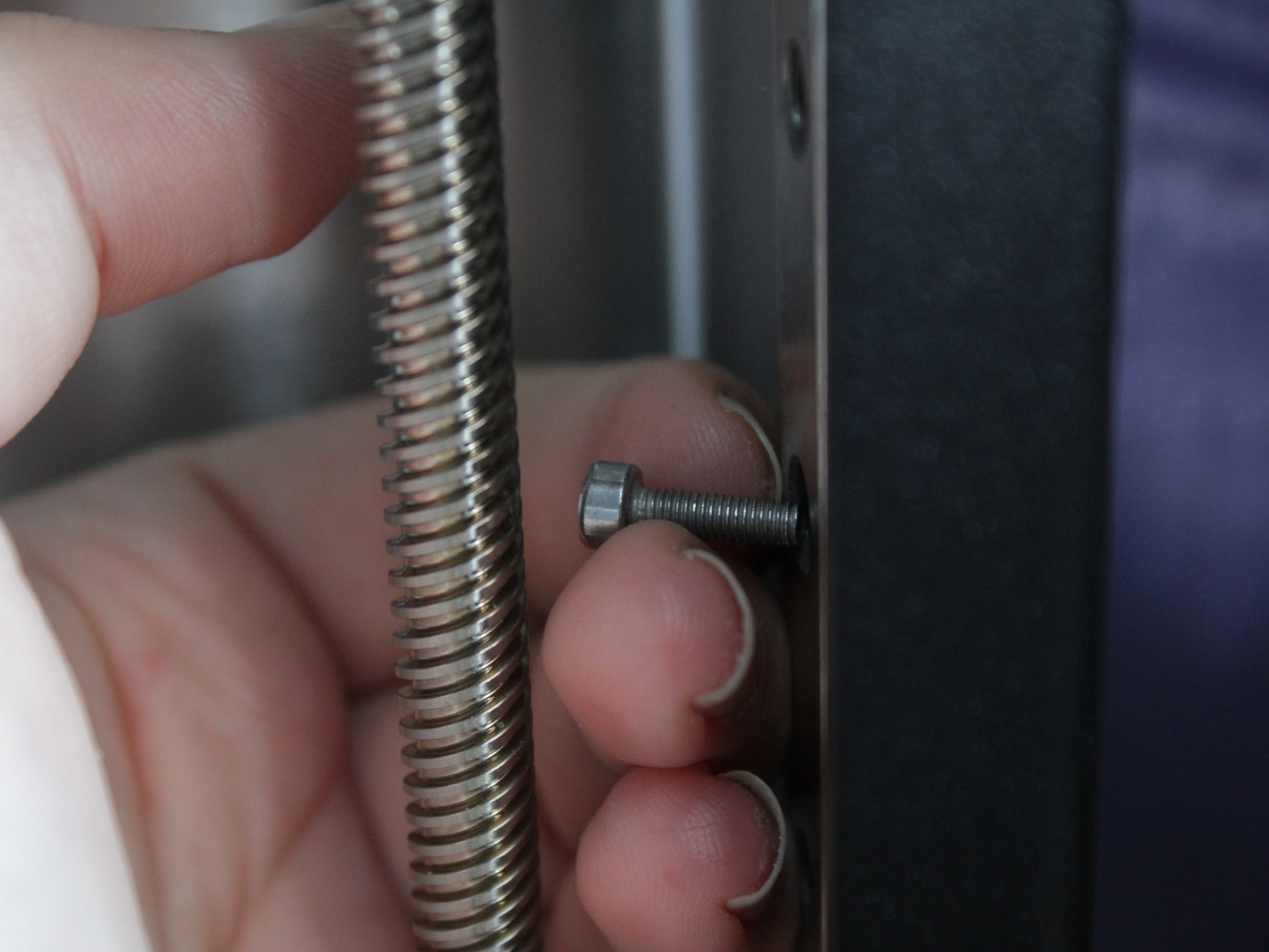 Pushing new M3x16 bolt through mounting point while old bolt comes out