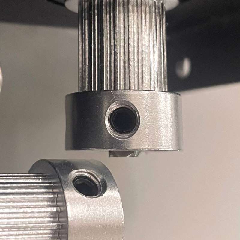 Pulley set screw being loosened with 2 mm hex screwdriver.