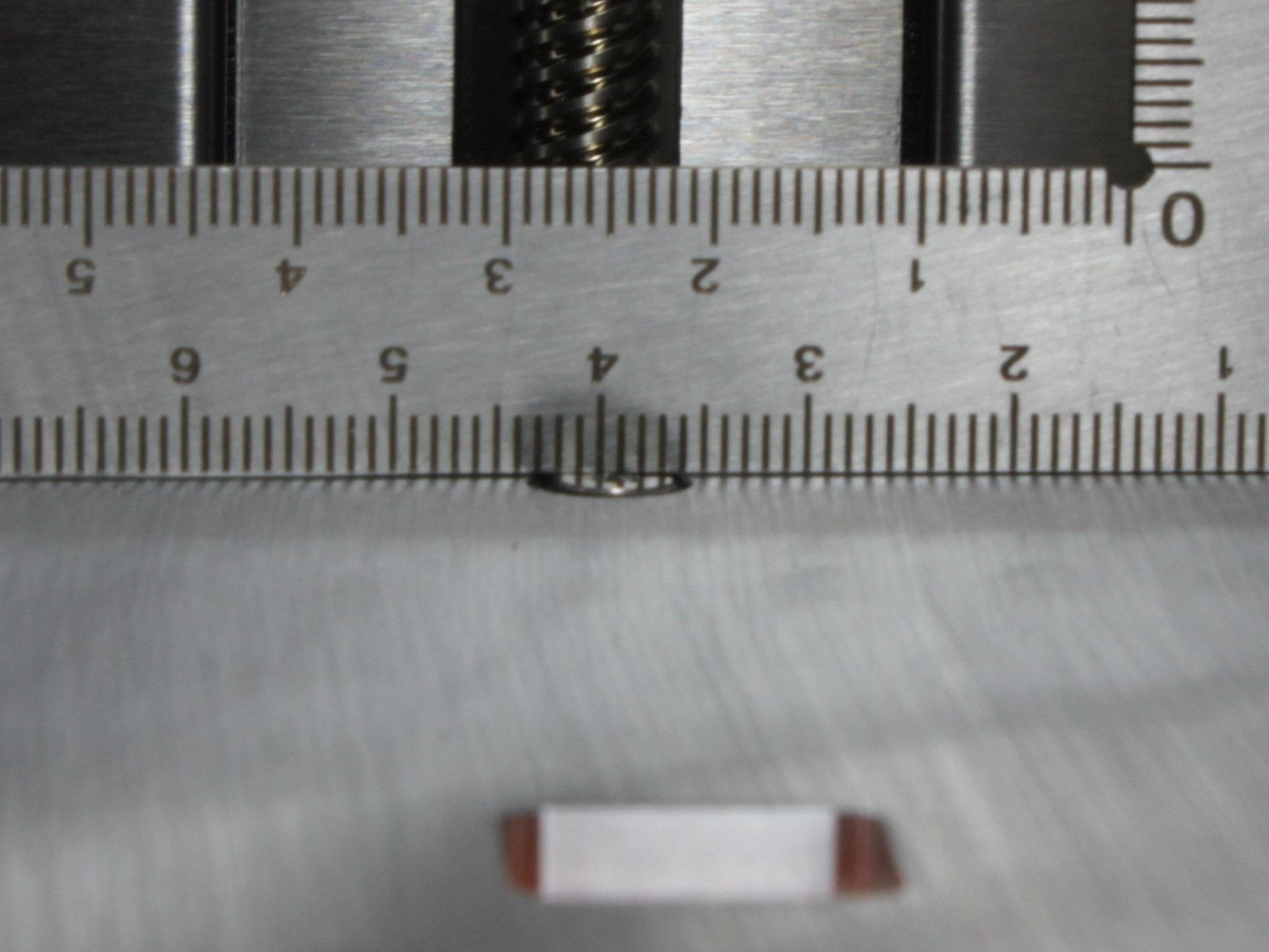 Correct: the rear screw head is flush with or slightly below the bed surface.