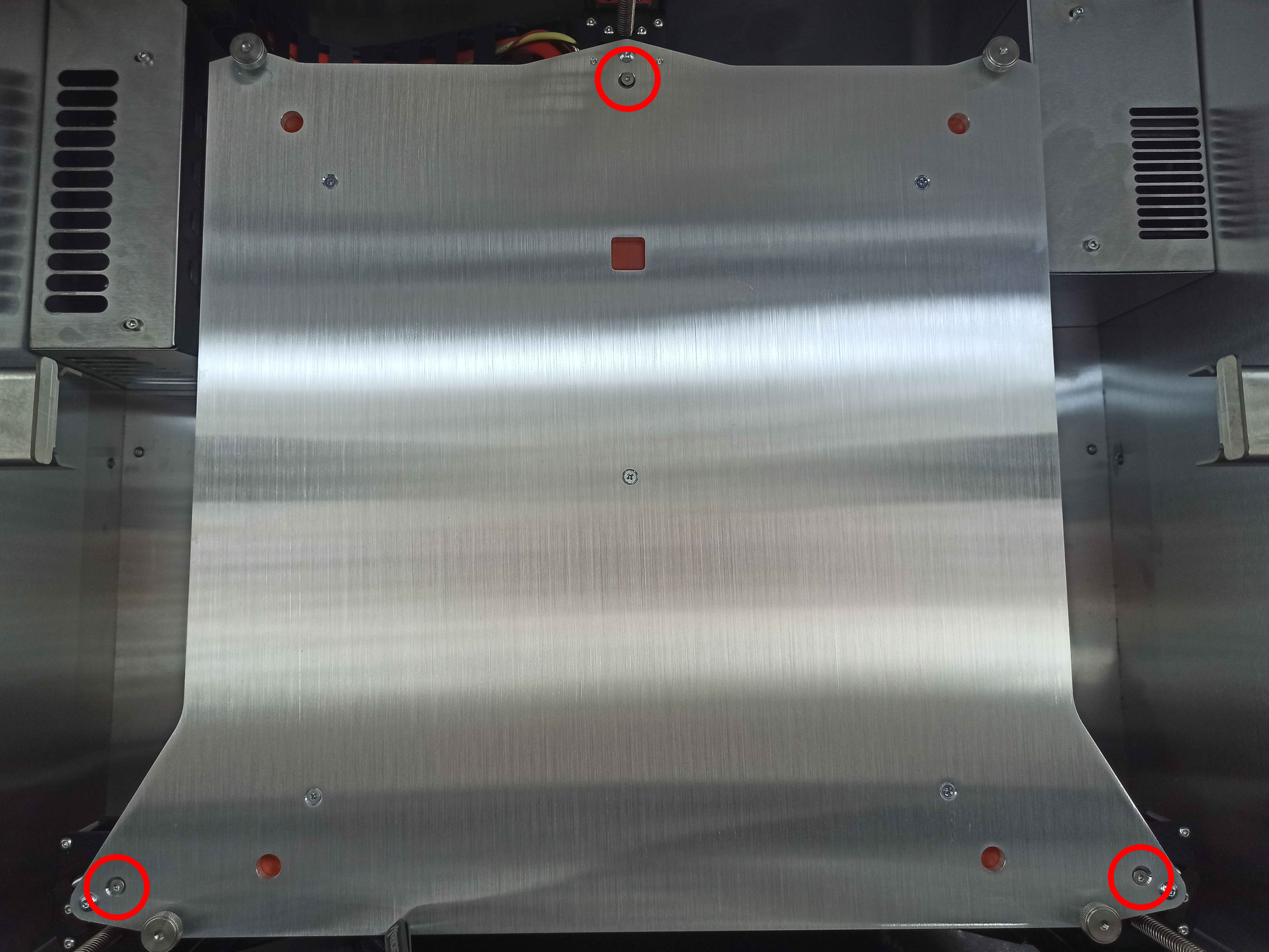 Overview of all three build plate securing screw locations: front left, front right, and rear center.