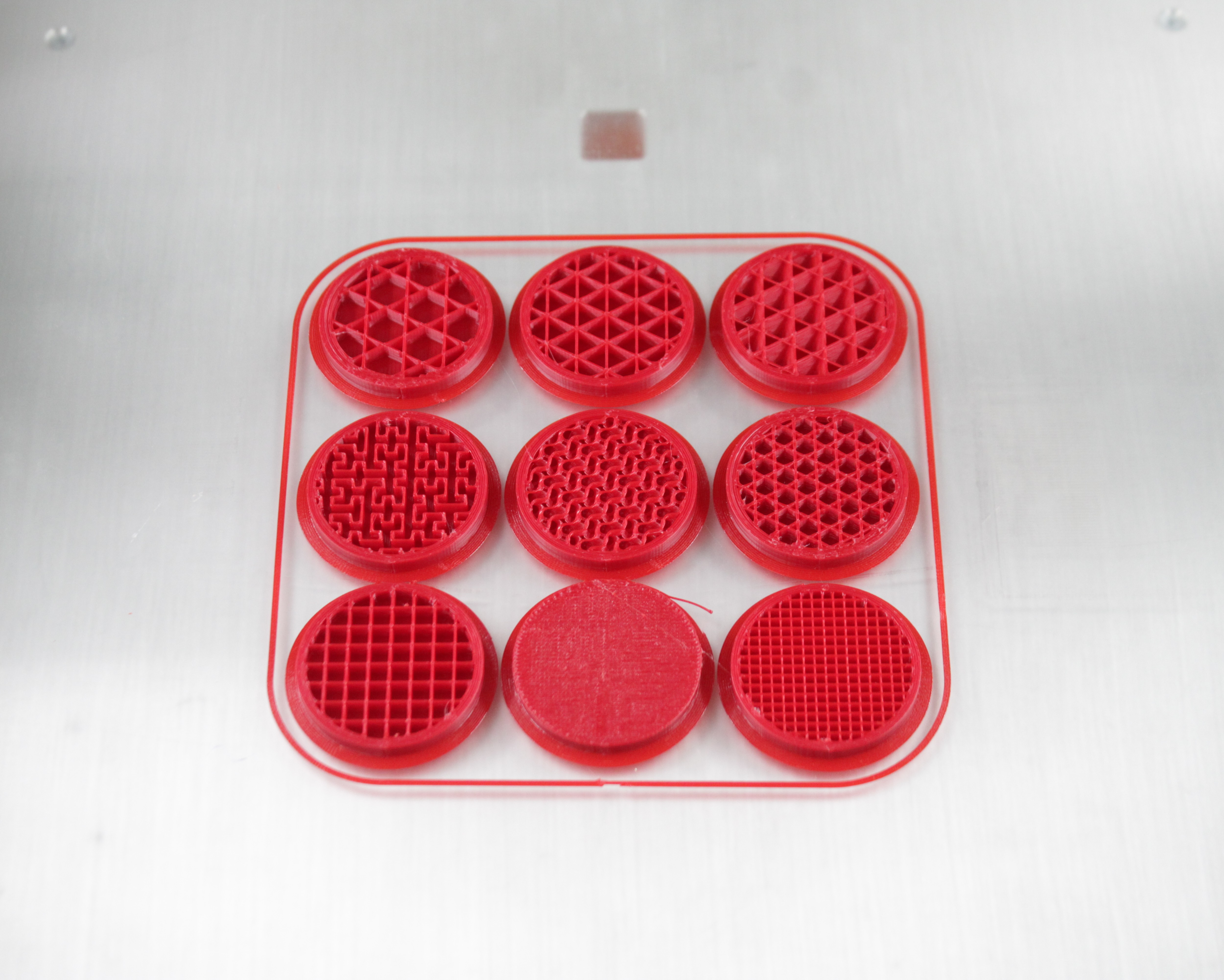 Nine test discs printed with different infill patterns, densities, and perimeter counts