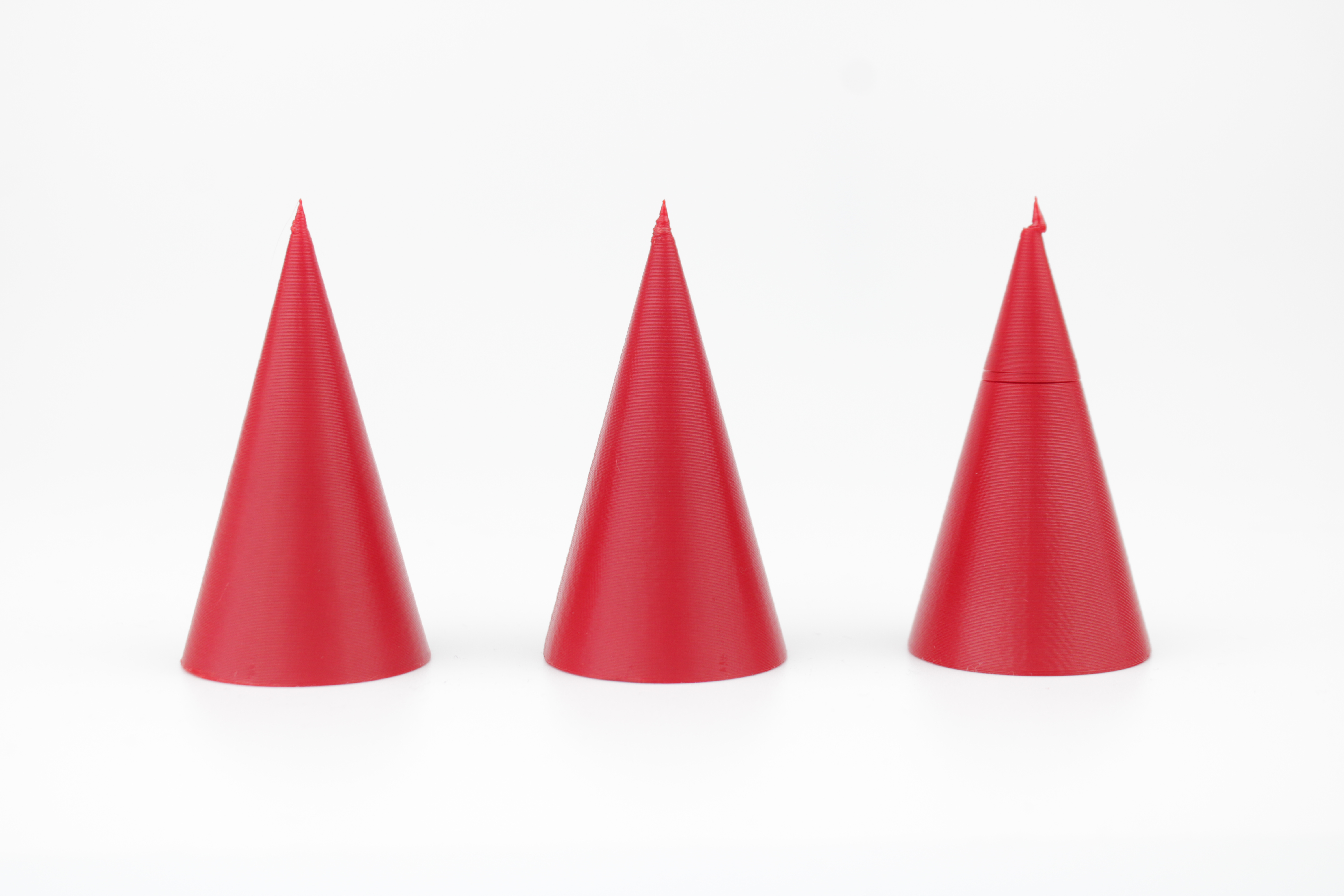 Three identical cones printed with different minimal layer times, the rightmost showing a deformed tip and a visible step