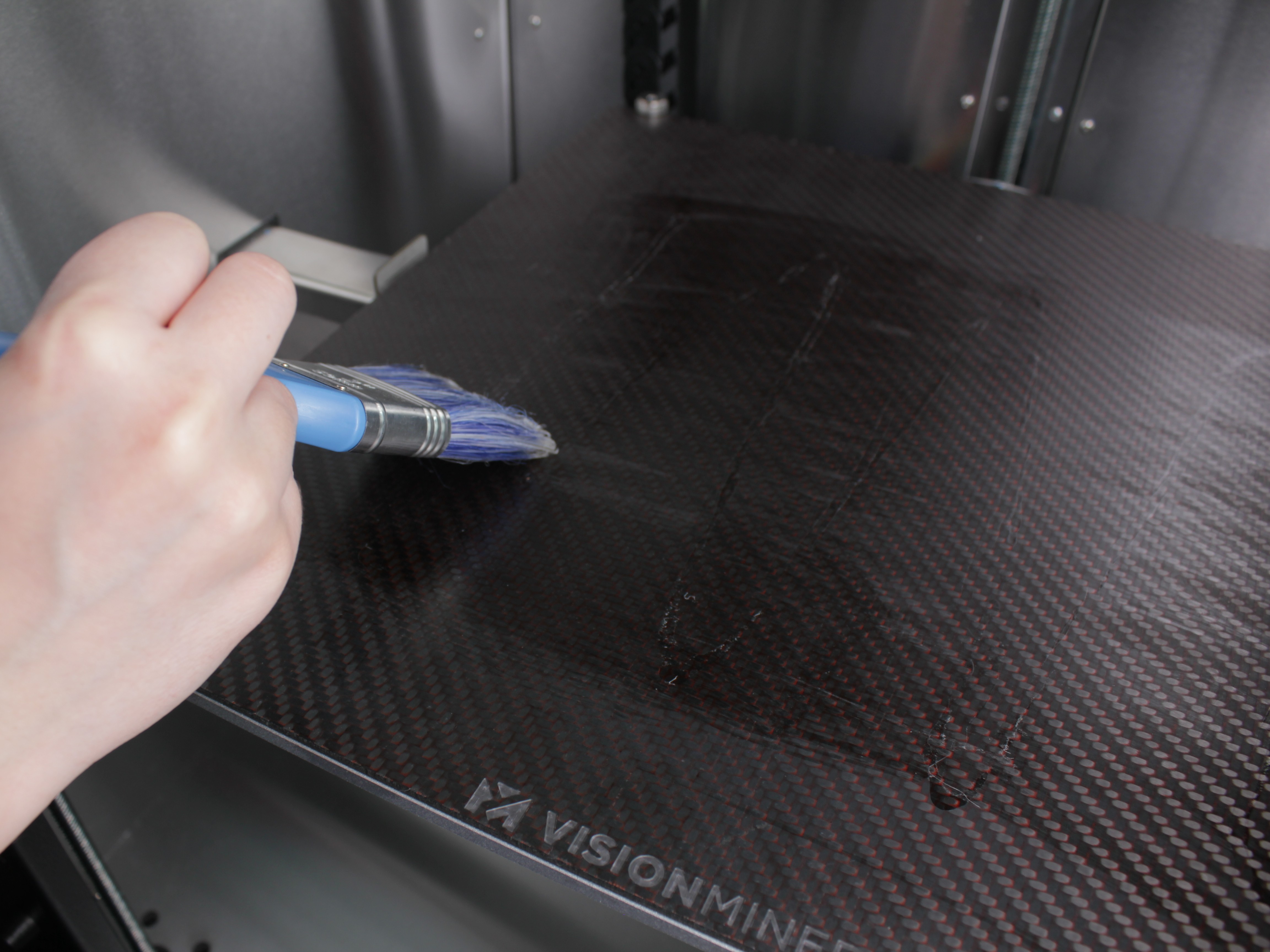 Brushing NPA with vertical strokes perpendicular to first coat for even coverage