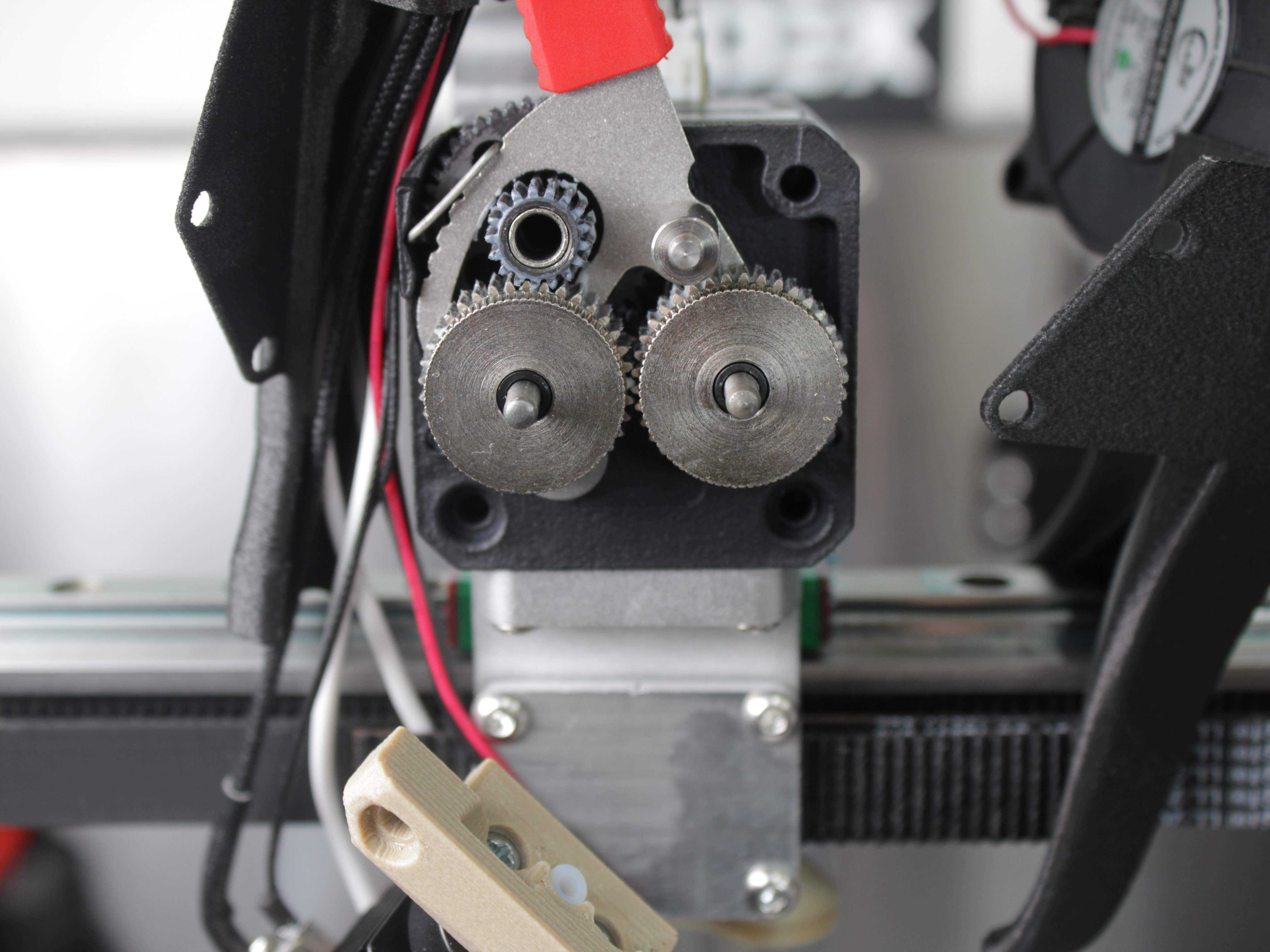 Front extruder panel screws and exposed drive gears ready for maintenance