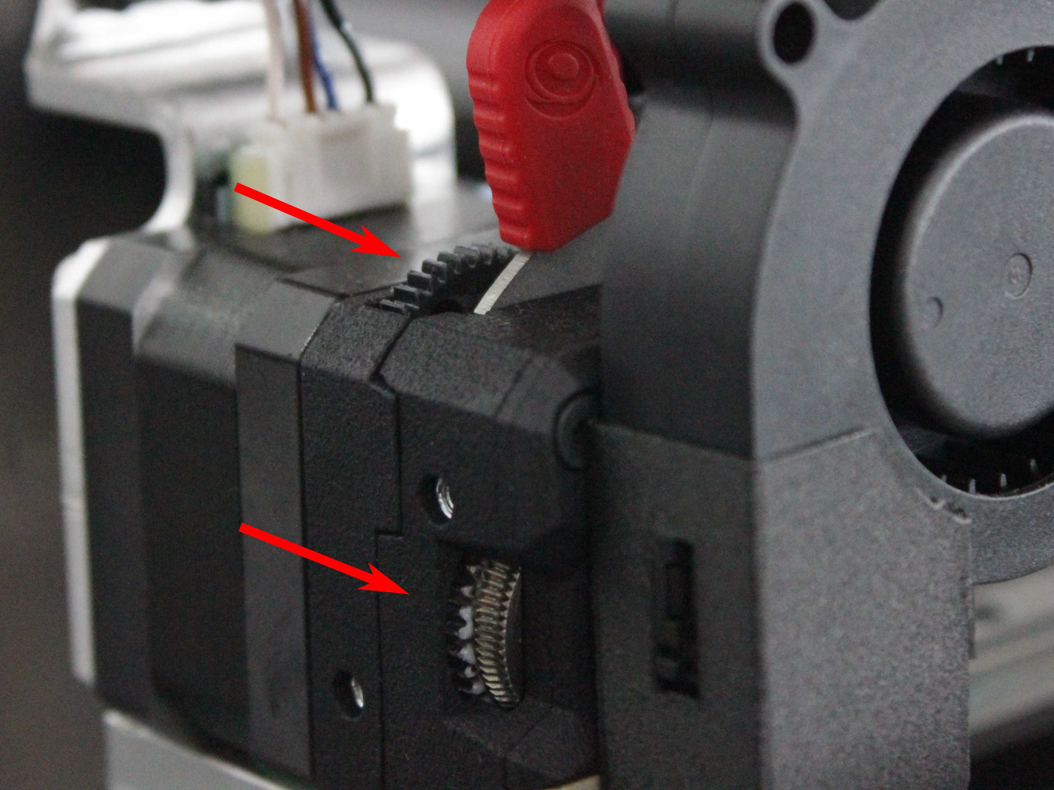 Inspecting the extruder drive gears for dust and debris.