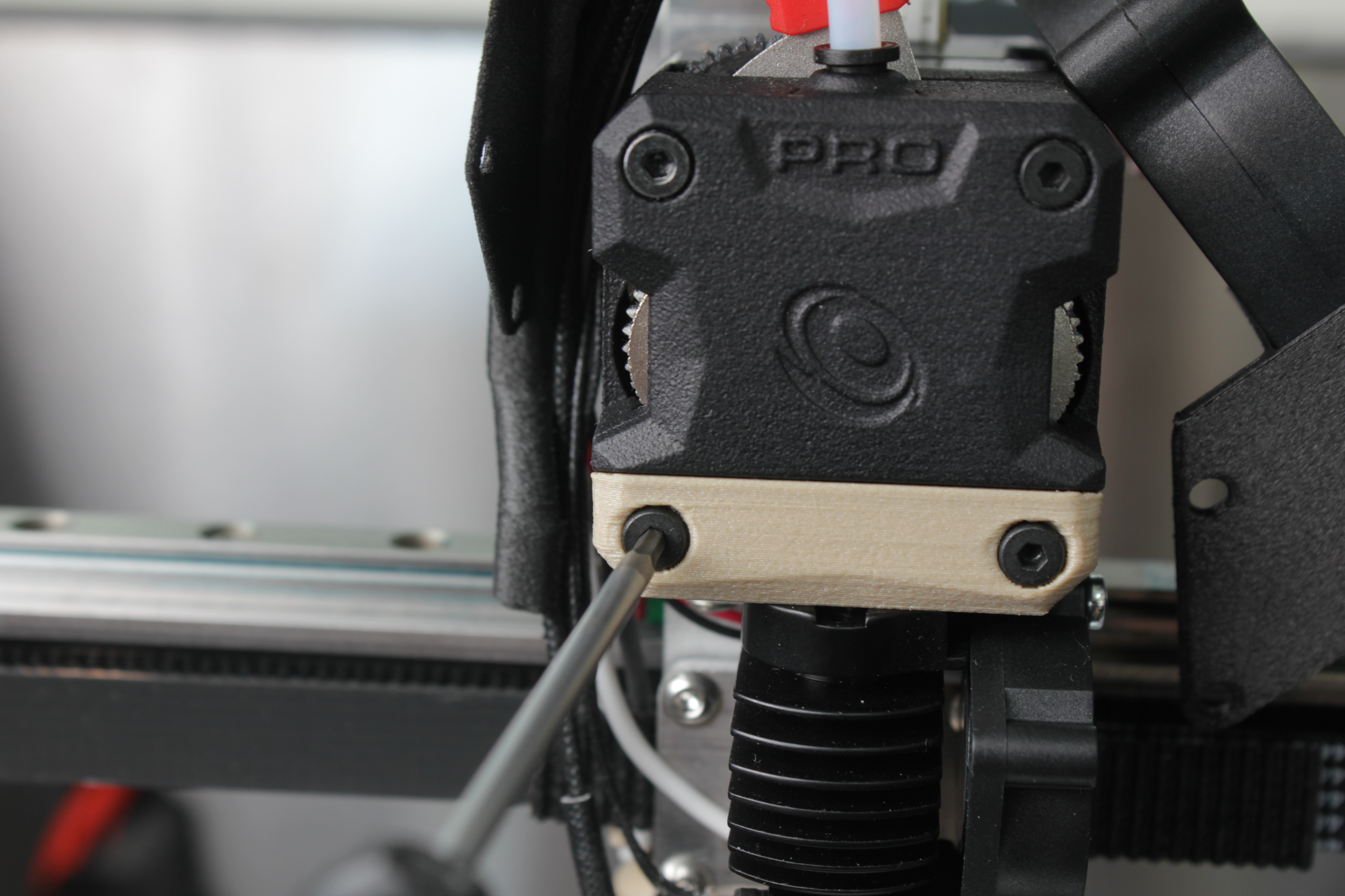 Removing the two bottom screws and interface plate from the extruder