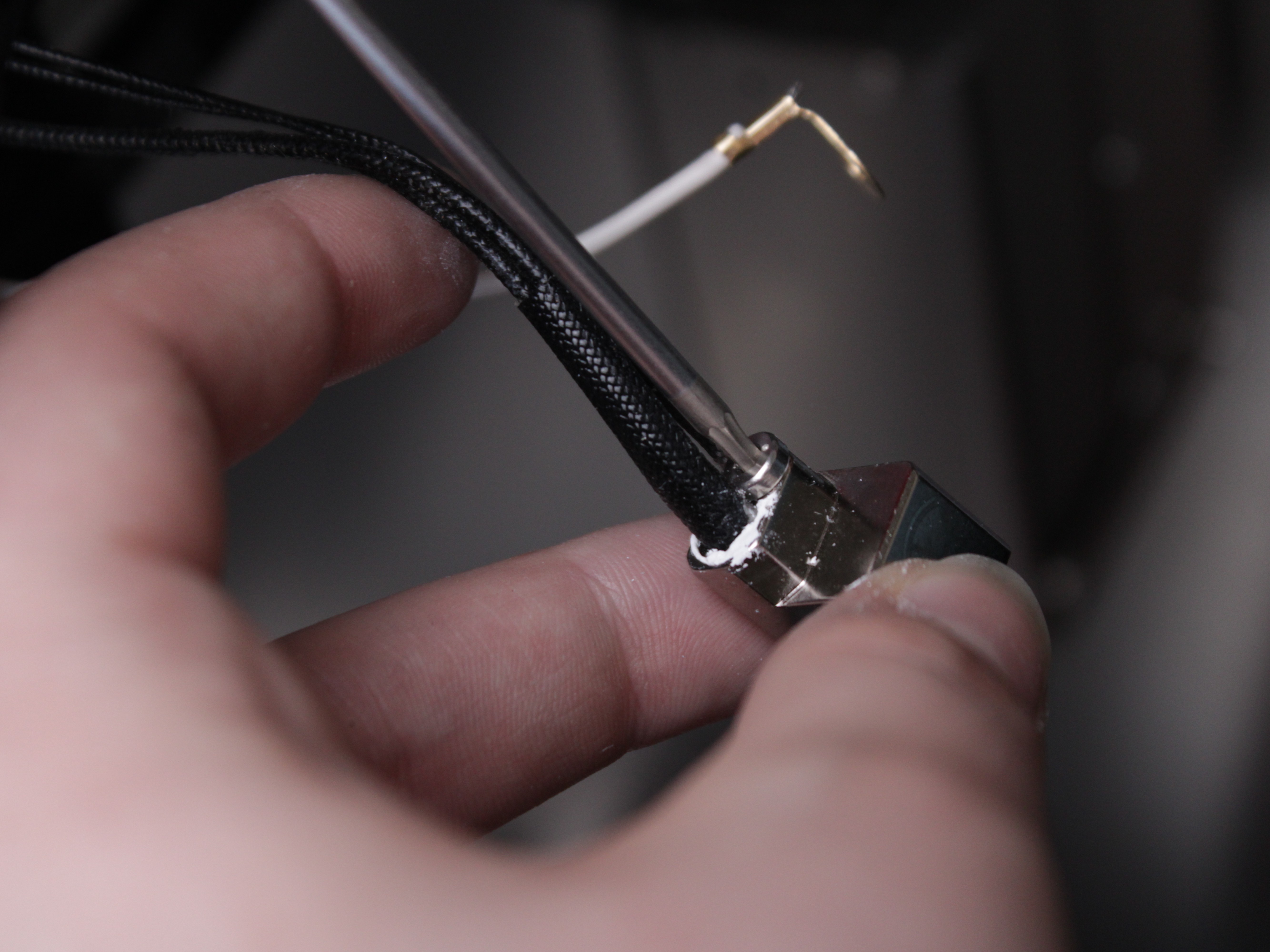 Unscrewing the set screw that holds the temperature sensor and heater cartridge