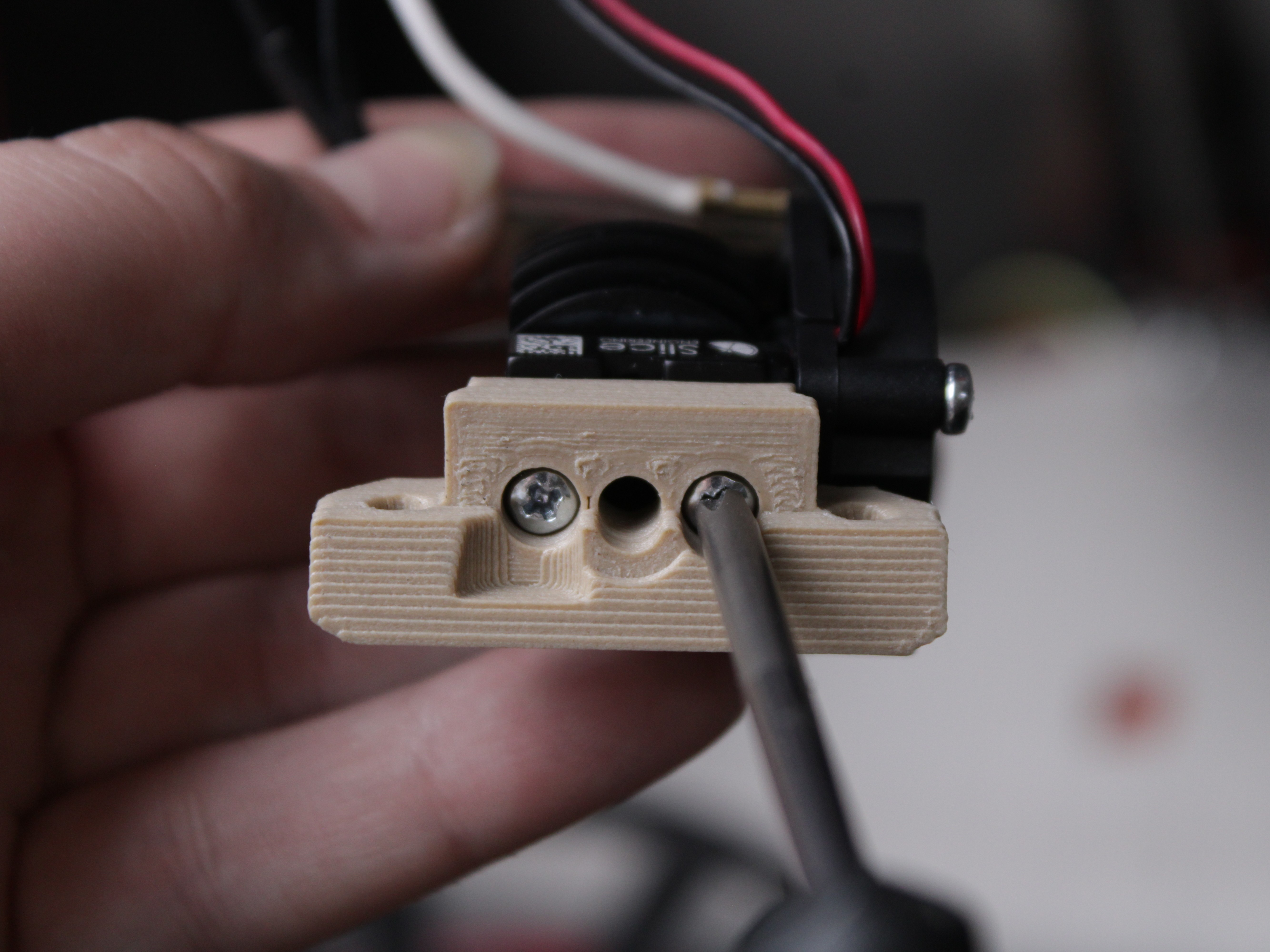 Unscrewing the 3D printed interface plate screws with a hex driver