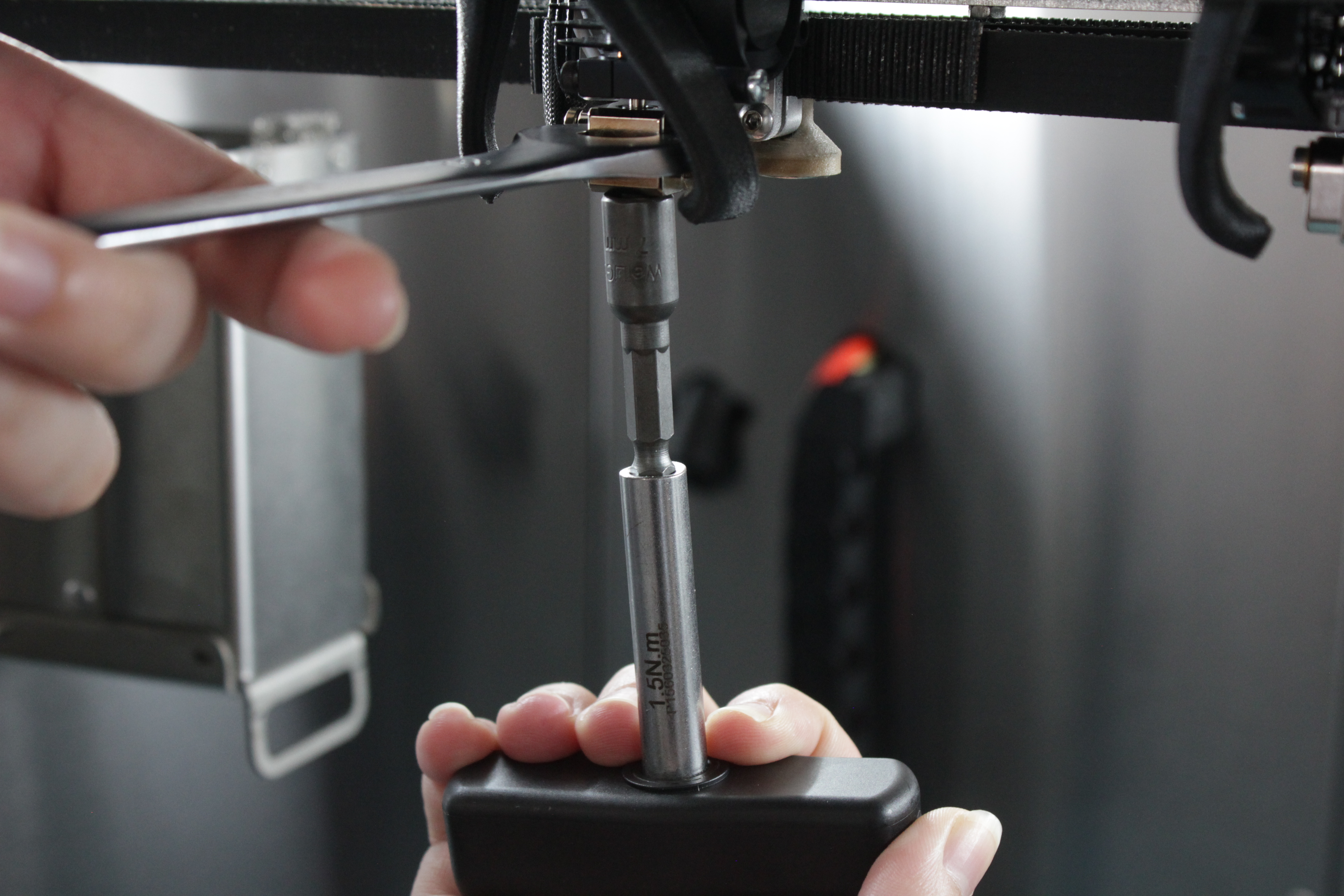 Final nozzle tightening with torque wrench while holding heat block