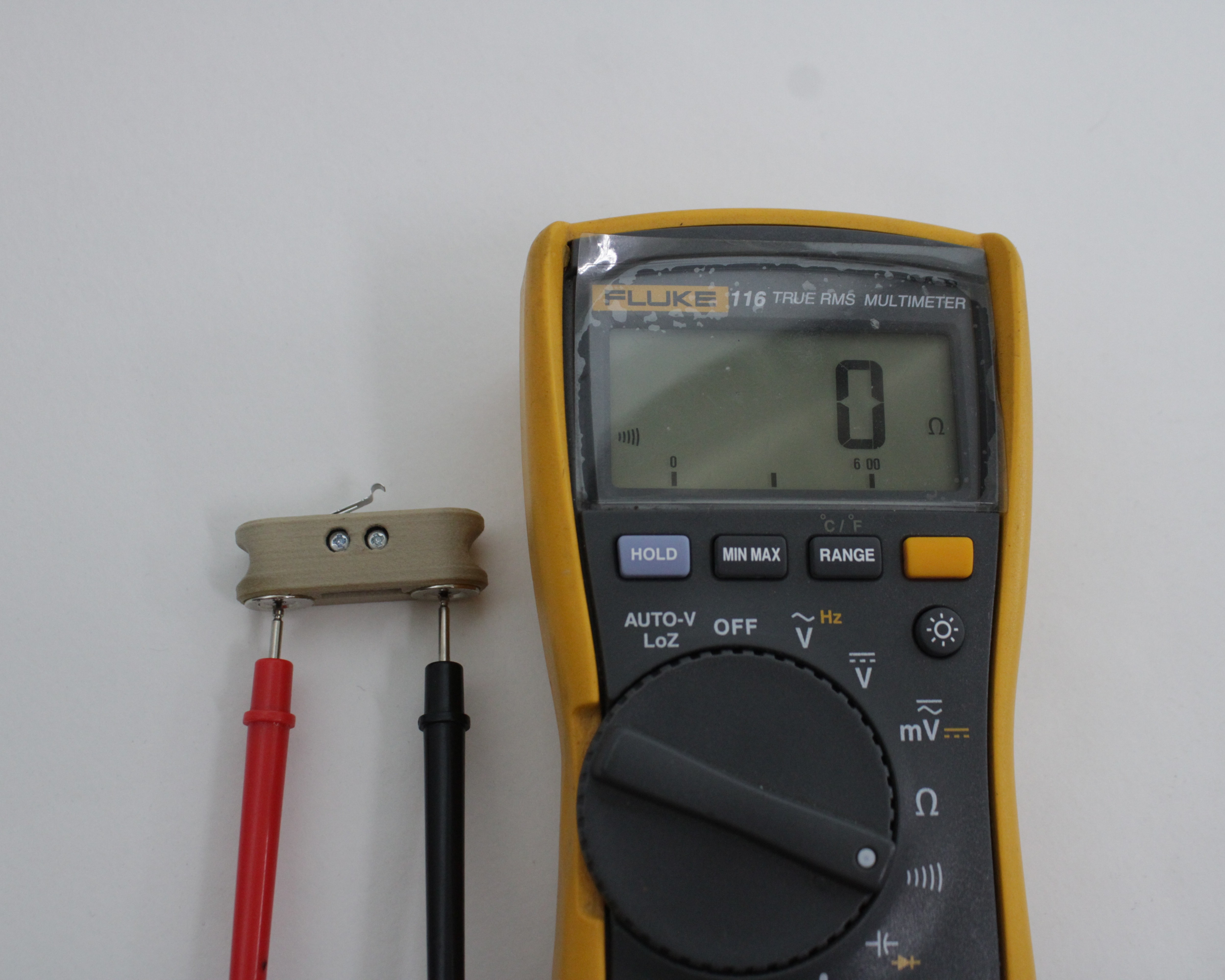 Multimeter in continuity mode with probes on the two magnet contacts on the Z-Probe body - plunger up, reads 0