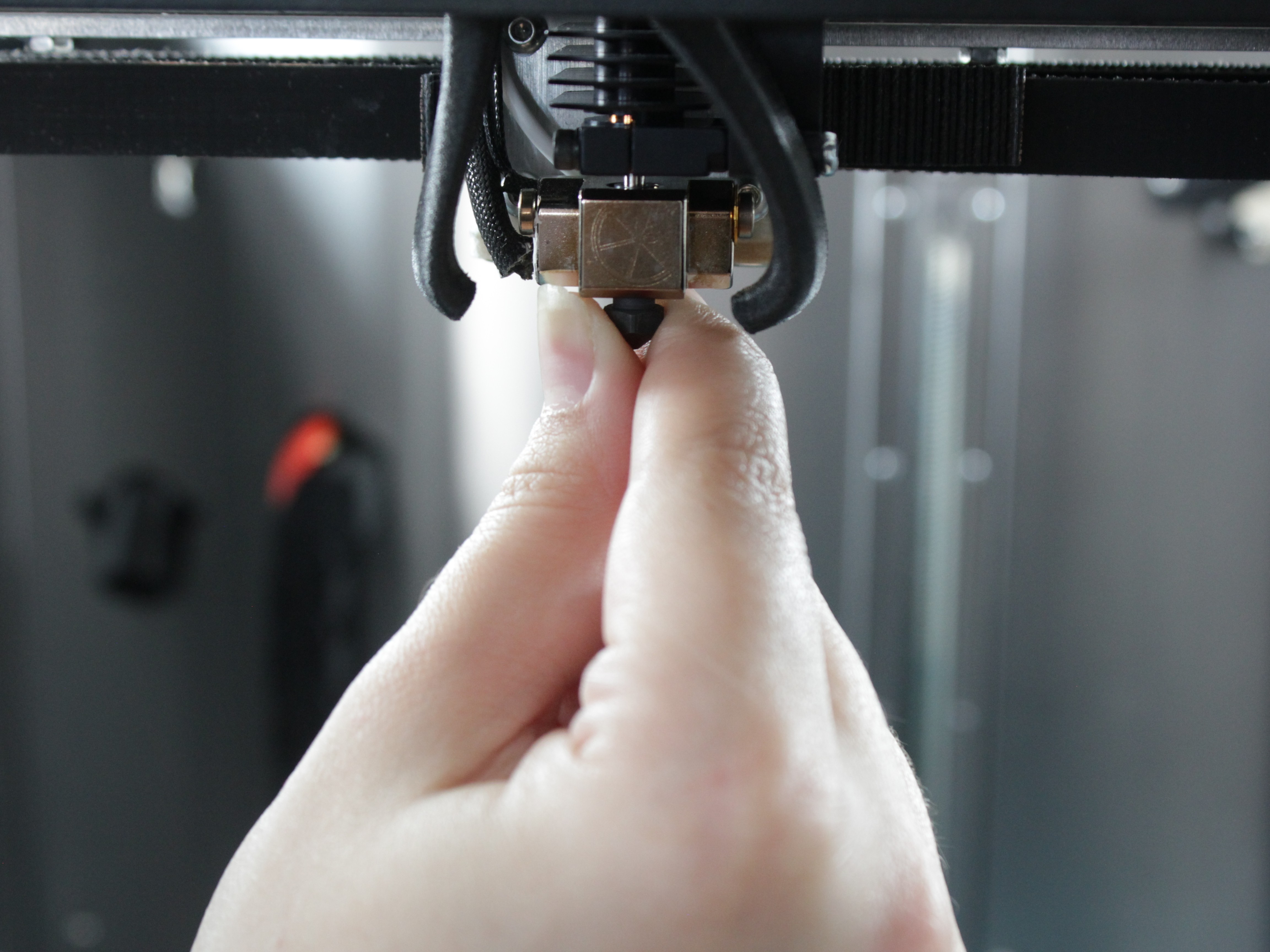 New nozzle being threaded into heater block by hand