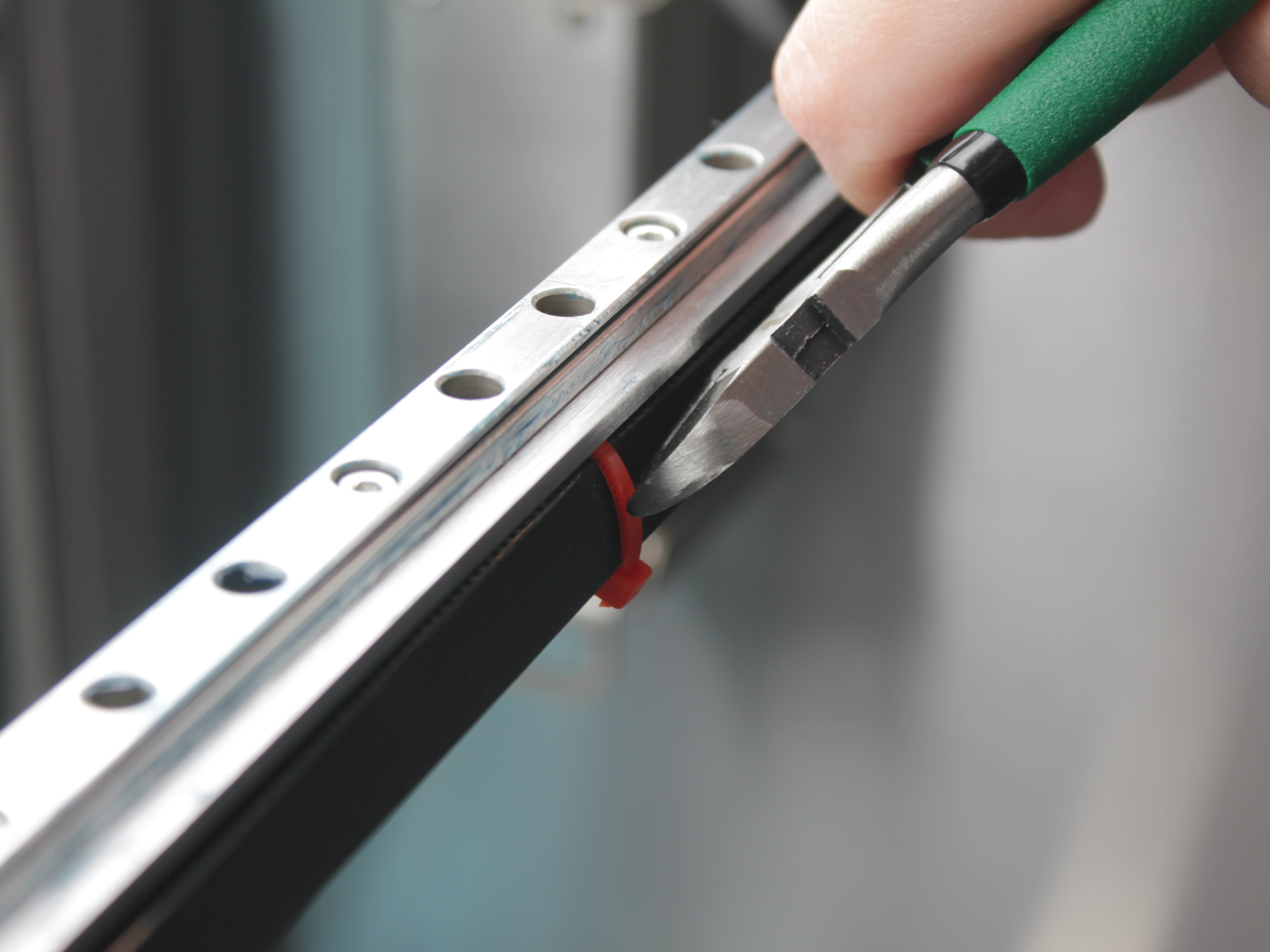 Cutting red zip tie securing tool 1 belt in center