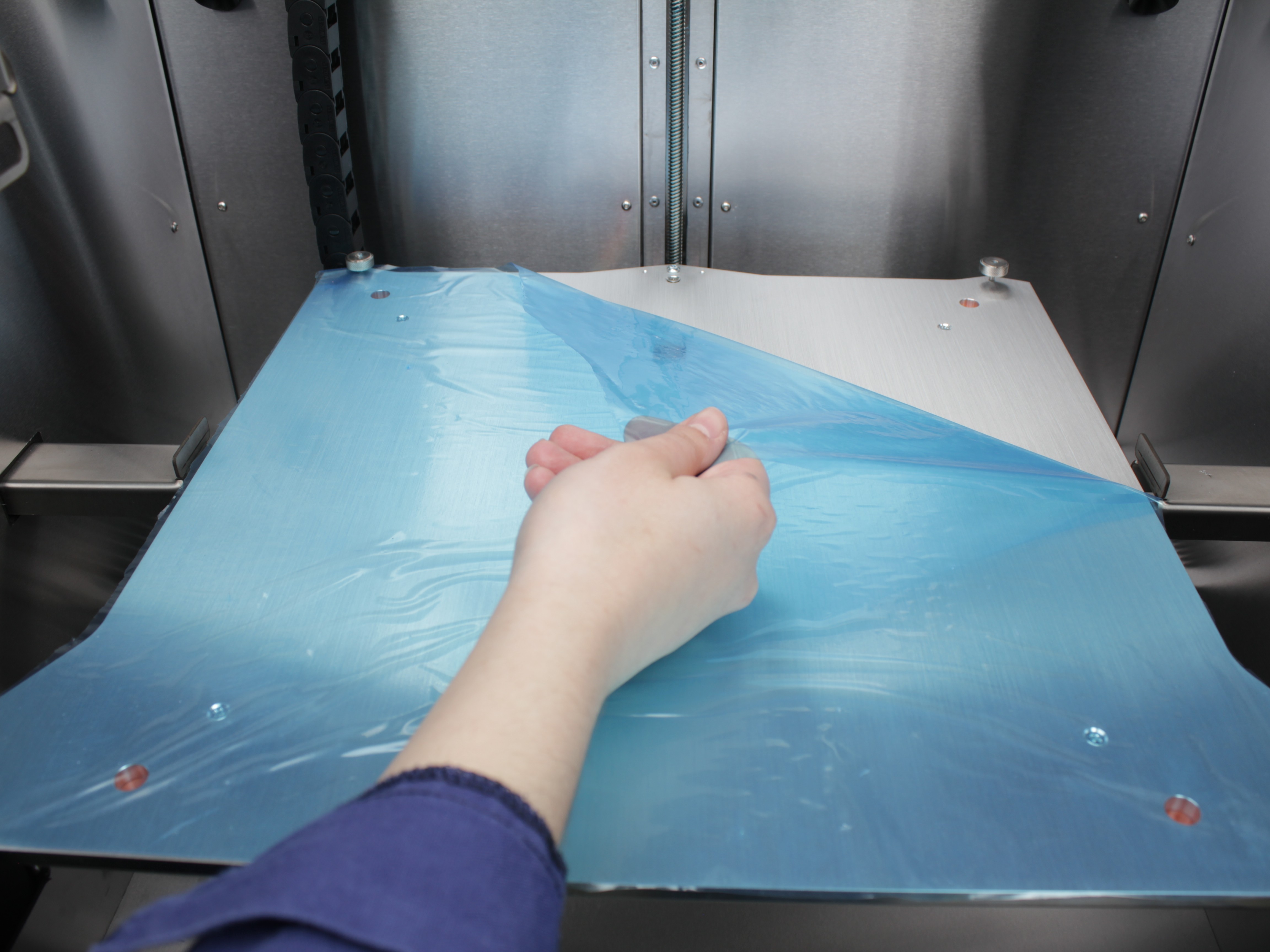 Peeling protective film from build plate surface