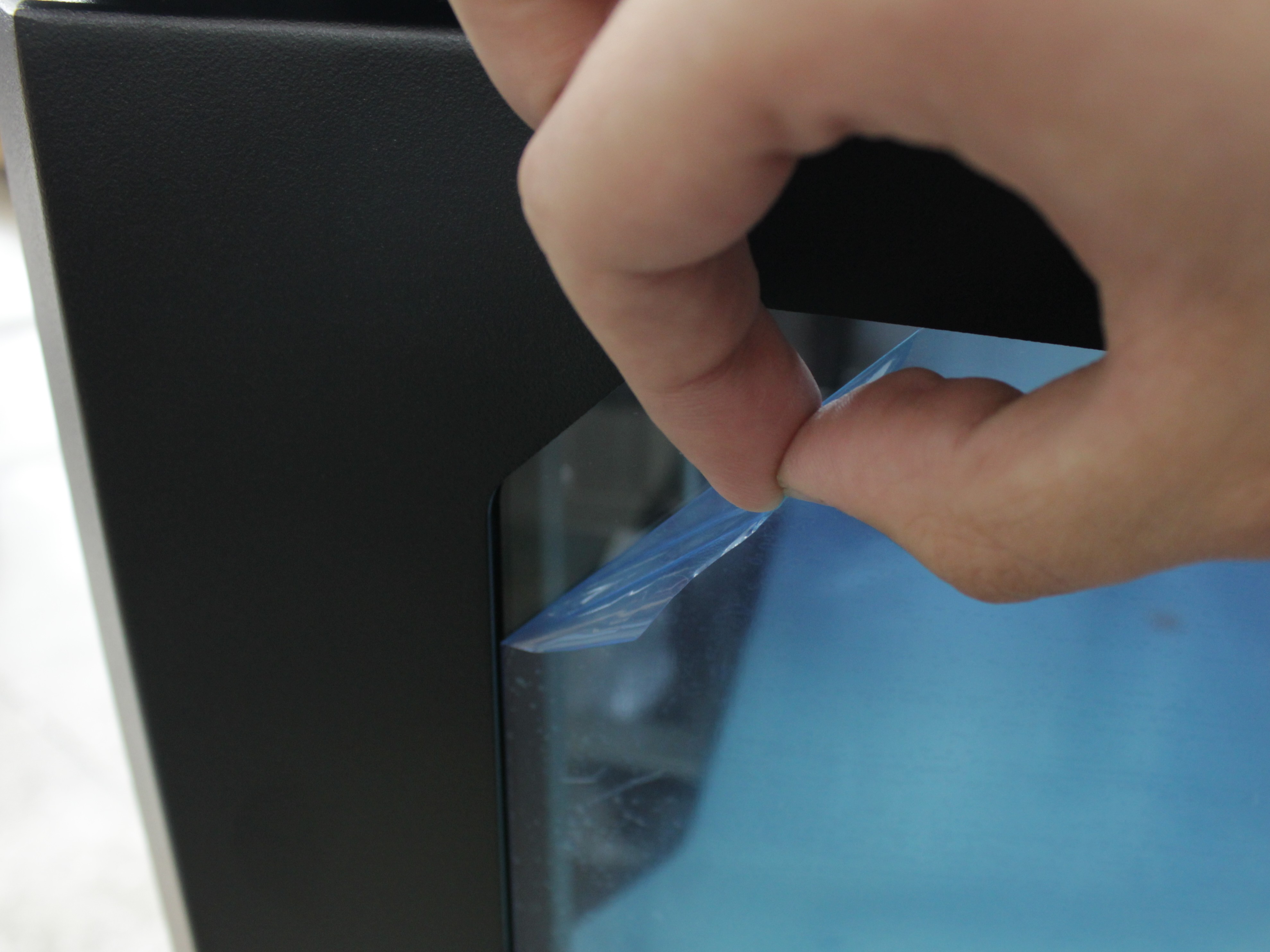 Peeling protective film from door glass