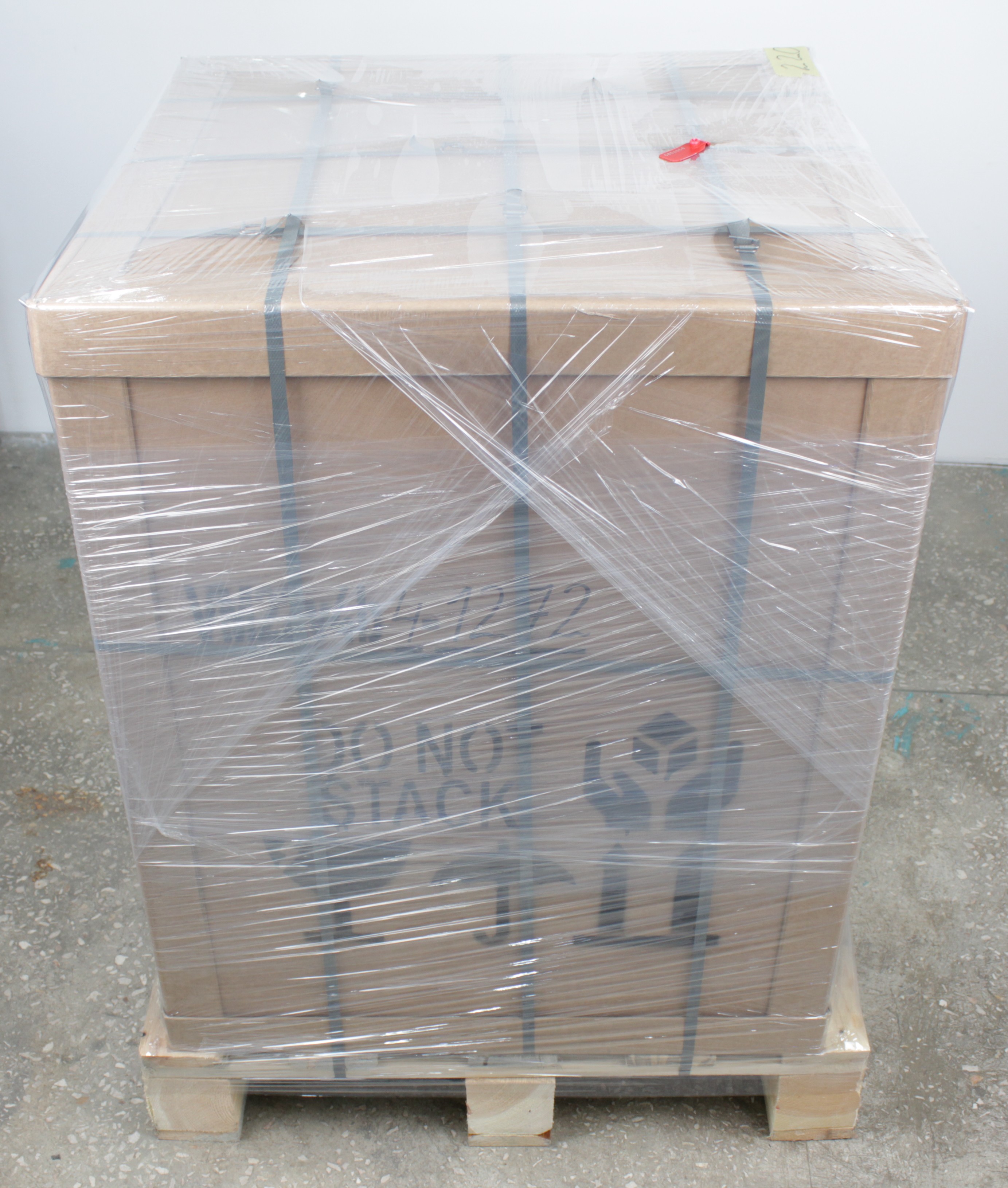 Printer in shipping crate wrapped in protective film as delivered