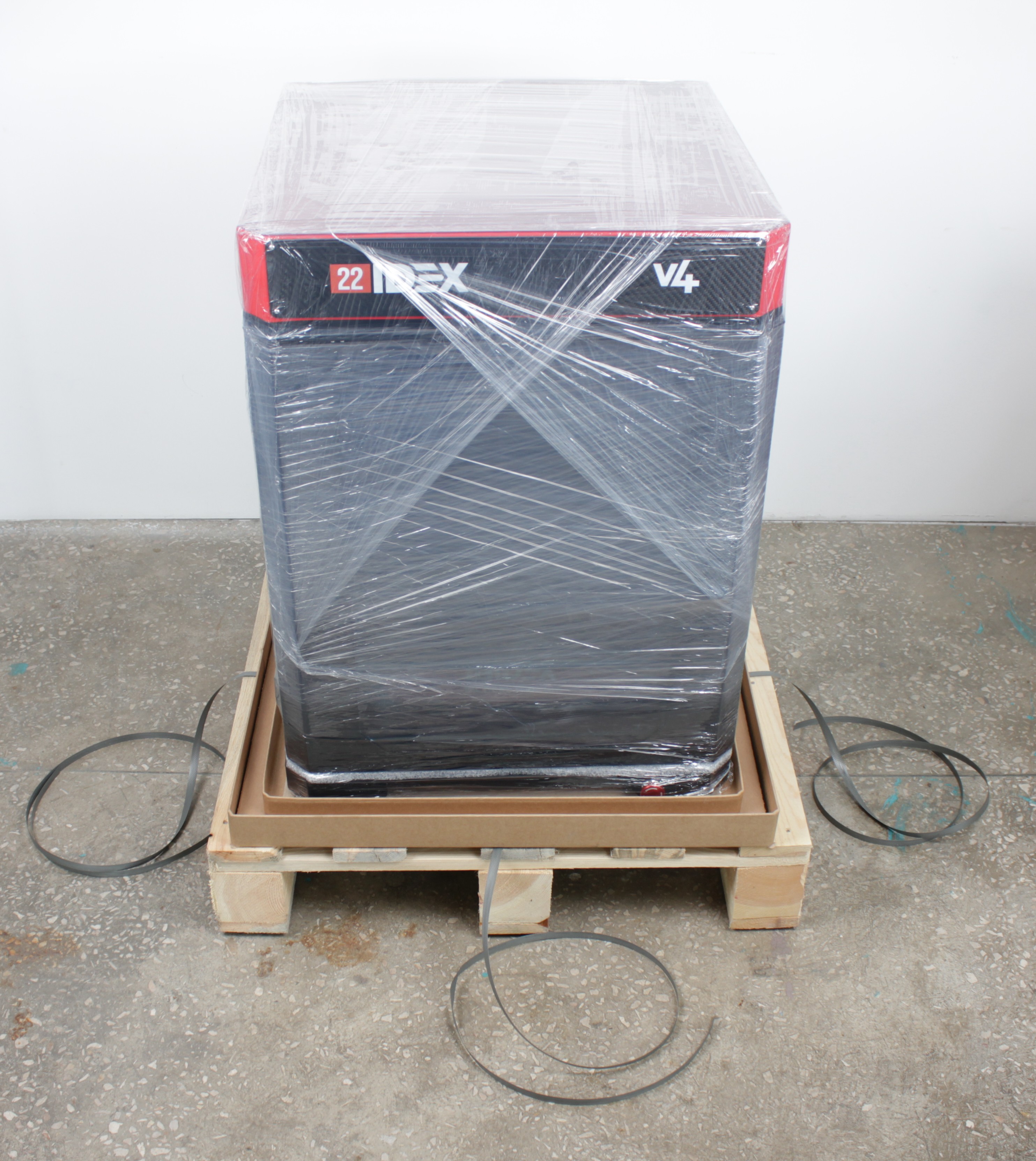Printer wrapped in plastic film and straps inside shipping crate